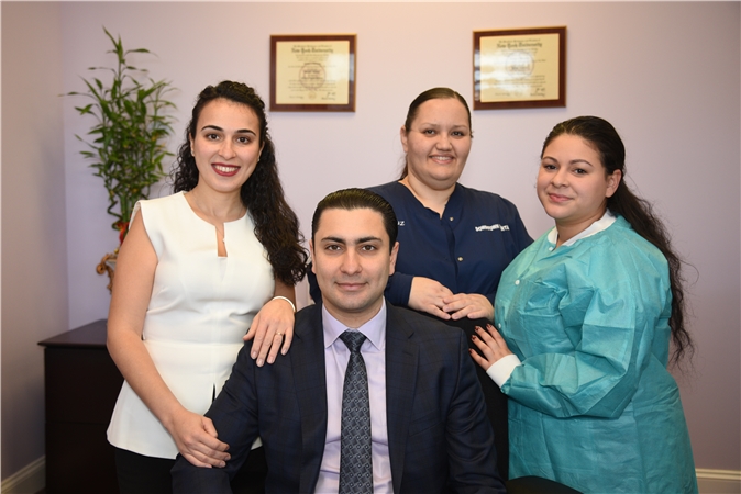 A group of three people posing for a photo in an office setting, with two women and one man standing behind the camera.