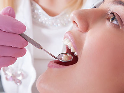 A dental professional performing a procedure on a patient s teeth.